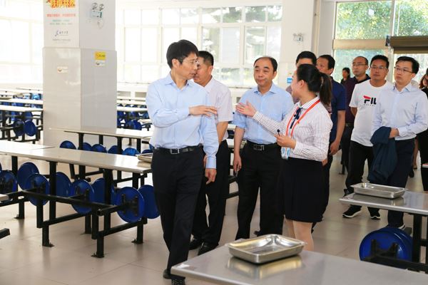 朱世宏（左一）在西宁中学察看食堂.JPG