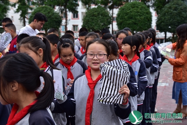 拿到三江镇党委政府发的慰问品，学生露出开心的笑容.JPG