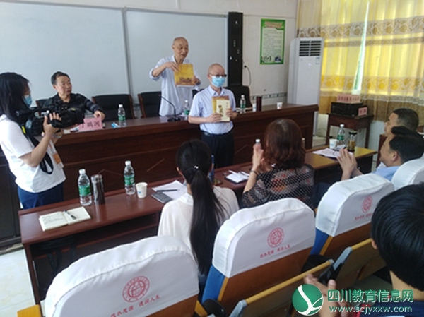 张思智向思德小学校长刘琦赠送学习“两德”的书籍.jpg